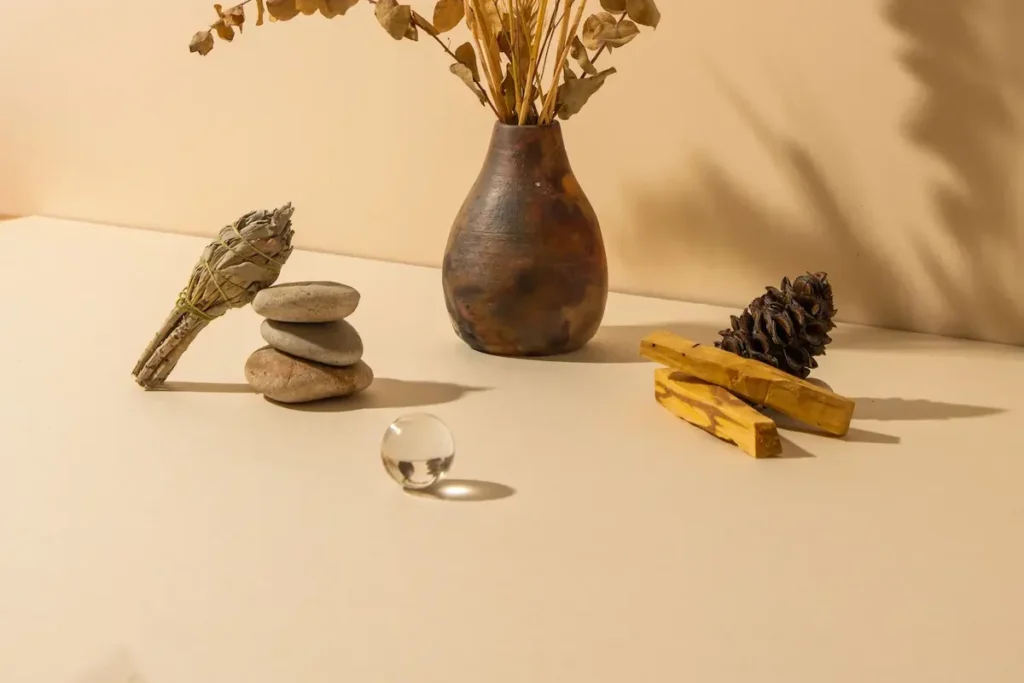 Cristal, sauge, pierres naturelles et fleurs séchées symbolisant un espace de bien-être et d'harmonie.