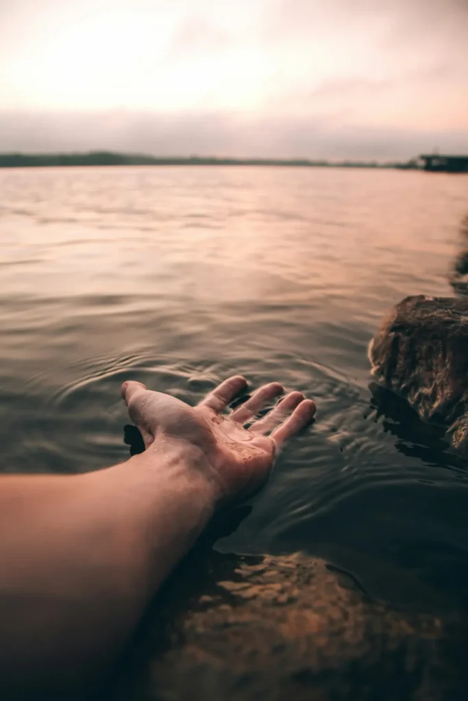 Main tendue vers l'eau illustrant un soin énergétique de guérisseur spirituel à Vedène